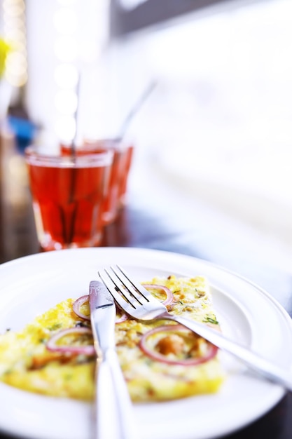 Close-up de pizza de bacon, suco de laranja em um copo na mesa em um café em um restaurante