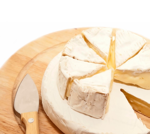 Foto close-up de queijo com faca de cozinha em tábua de cortar sobre fundo branco