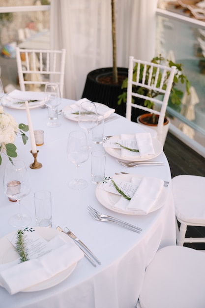 Close up de recepção de mesa de jantar de casamento de uma mesa redonda de casamento com pratos brancos e um menu