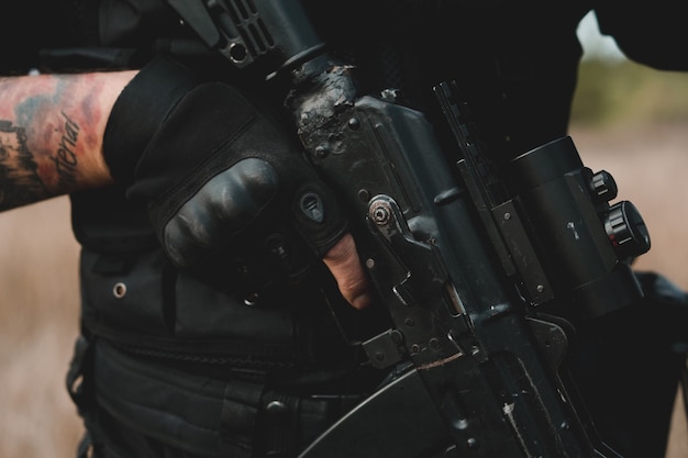Close up de rifle de assalto preto com mira de colimador