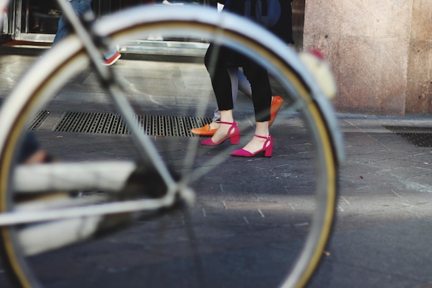 Foto close-up de roda de bicicleta com seção baixa de mulheres no fundo