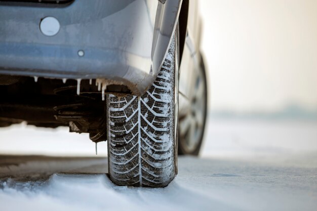 Close-up de rodas de carro pneus de borracha na estrada de neve no inverno profundo