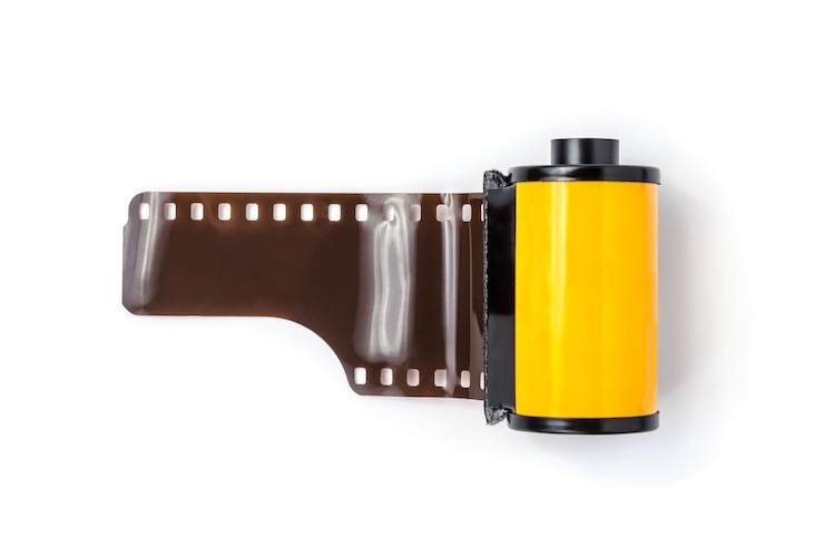 Foto close-up de rolo de filme amarelo contra fundo branco