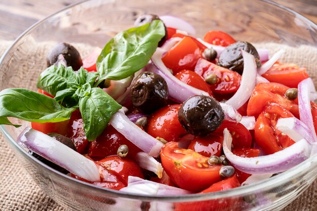 Close up de salada fresca com conceito de dieta alimentar de tomate cereja, azeitonas, cebola e especiarias