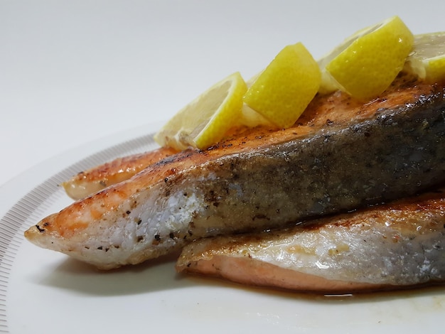 Close-up de salmão grelhado adornado com fatias de limão