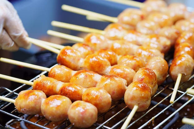 Close-up de salsicha grelhada estilo tradicional tailandês Sai krok isan porco e arroz mercado de comida de rua tailandesaxDxA