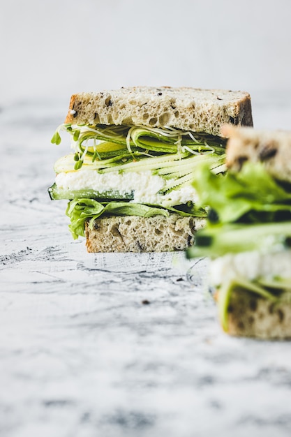 Close-up de sanduíche vegetariano com legumes verdes. Alface, abobrinha, alfafa e pepino. Comida vegana.