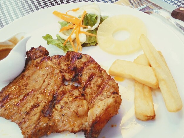 Foto close-up de servindo schnitzels de salsicha com batatas fritas em prato