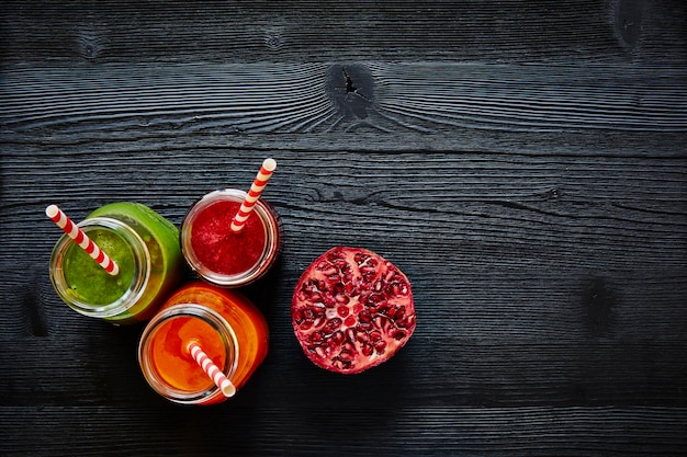 Close-up de smoothie em frascos com romã na mesa