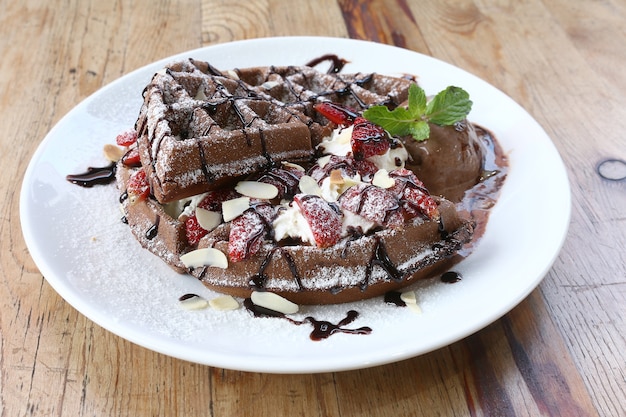 Close-up de sorvete de chocolate com waffle e morango fresco no fundo da mesa de madeira