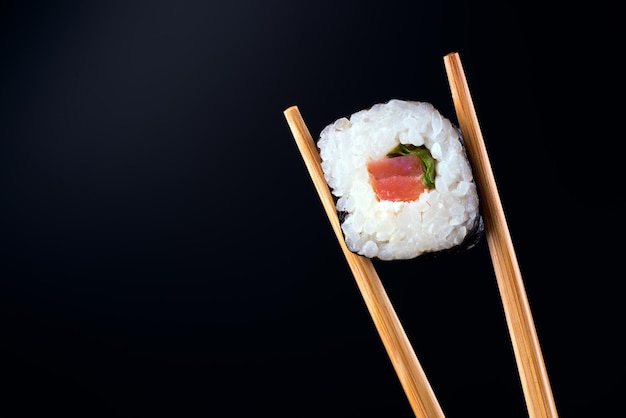 Close-up de sushi roll com salmão em fundo preto