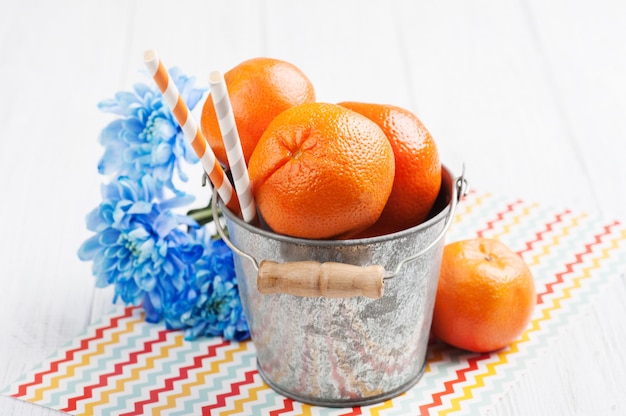 Foto close-up de tangerinas frescas em um balde de lata