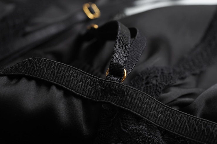 Foto close-up de tecido preto e fecho dourado em roupa interior feminina
