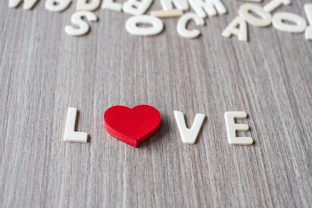 Foto close-up de texto de amor com forma de coração vermelho na mesa