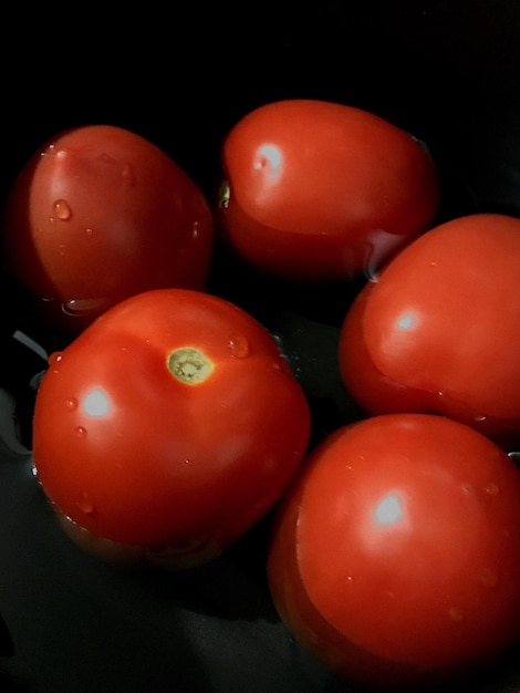 Foto close-up de tomates sobre um fundo preto