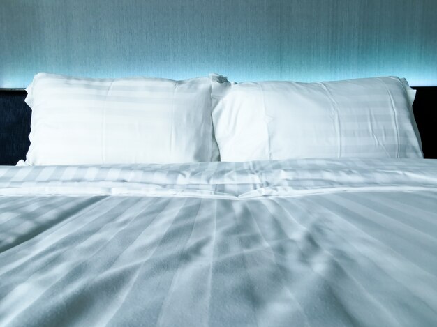 Close-up de travesseiro branco na cama de conforto branco