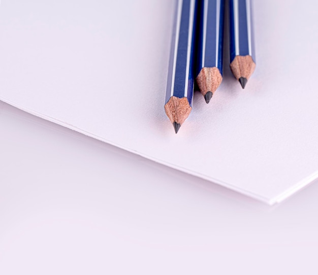 Close-up de três lápis em folhas de papel branco