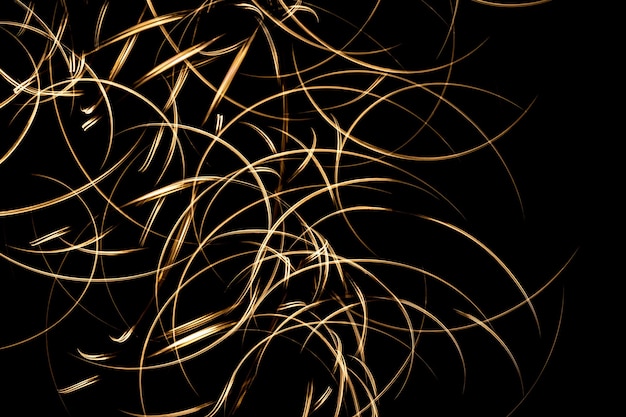 Foto close-up de trilhas de luz dourada em um fundo preto