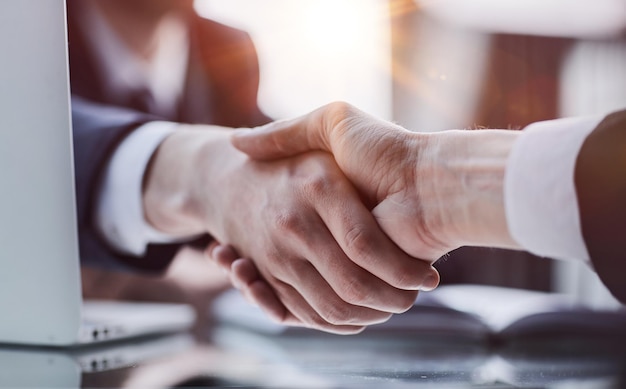 Close-up de um aperto de mão de saudação, mãos de um jovem empresário tremendo sobre a mesa de conferência