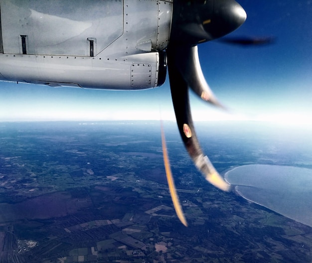 Close-up de um avião voando sobre o mar contra o céu