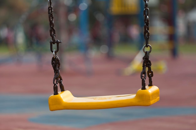 Close-up de um baloiço vazio pendurado no parque infantil