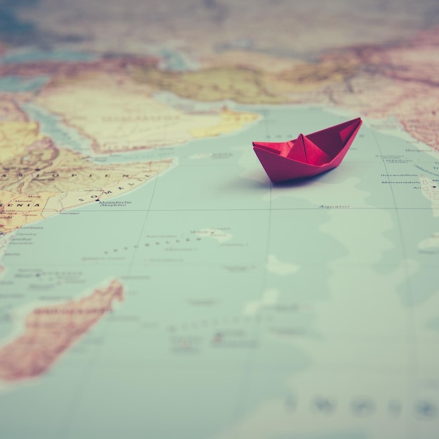 Close-up de um barco de papel vermelho no mapa