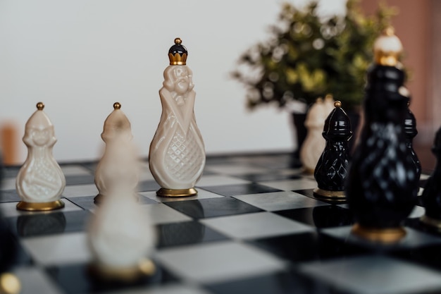 Foto close-up de um belo xadrez na mesa na sala foco seletivo de peças de xadrez de porcelana no tabuleiro de xadrez