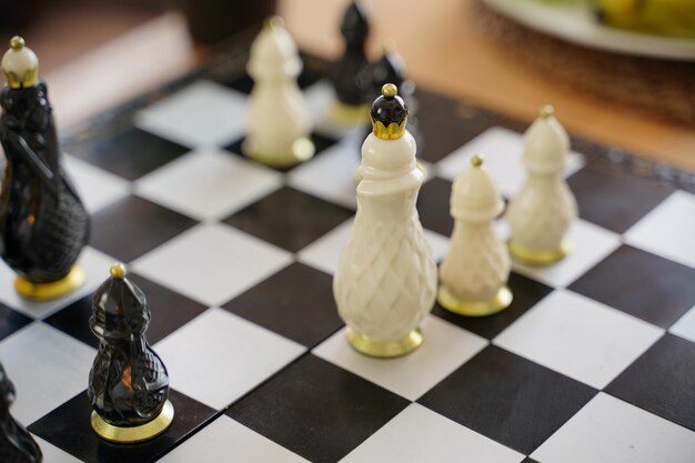 Close-up de um belo xadrez na mesa na sala Foco seletivo de peças de xadrez de porcelana no tabuleiro de xadrez