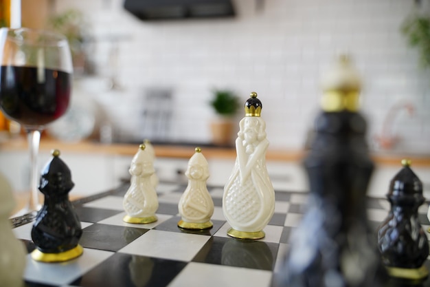 Close-up de um belo xadrez na mesa na sala Foco seletivo de peças de xadrez de porcelana no tabuleiro de xadrez