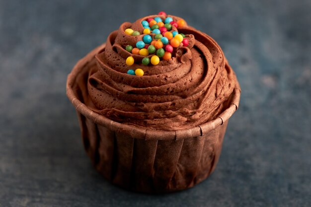 Close-up de um bolinho de chocolate com doces coloridos.