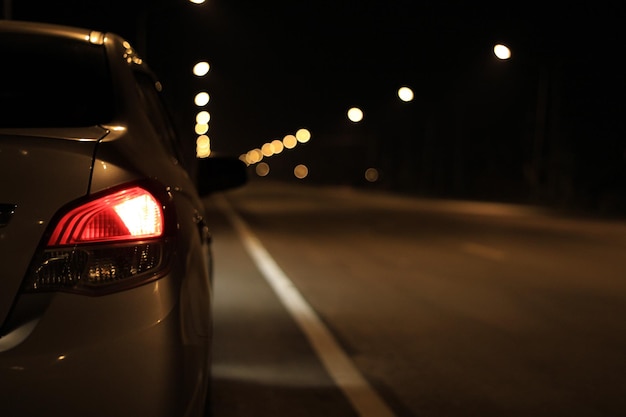 Close-up de um carro iluminado na estrada à noite
