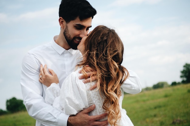 Close-up de um casal a beijar-se enquanto está de pé contra o céu