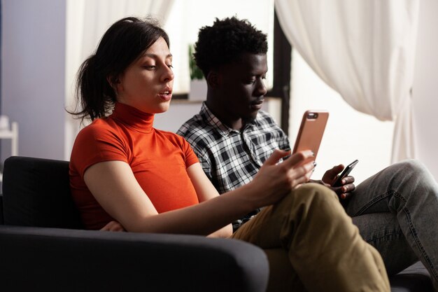 Foto close-up de um casal interracial moderno usando smartphones