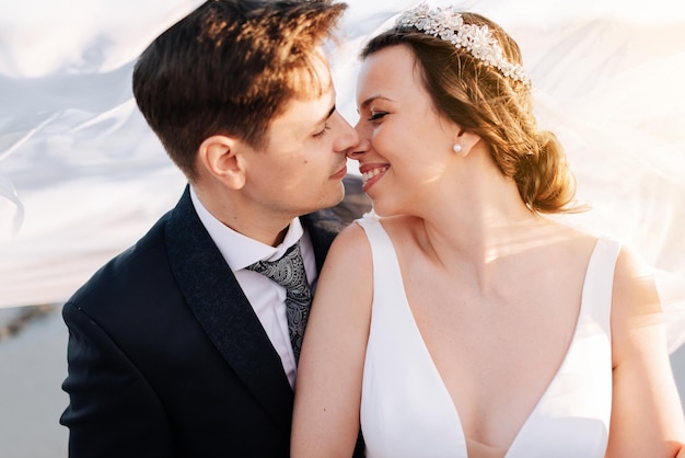 Close-up de um casal recém-casado a beijar-se na praia