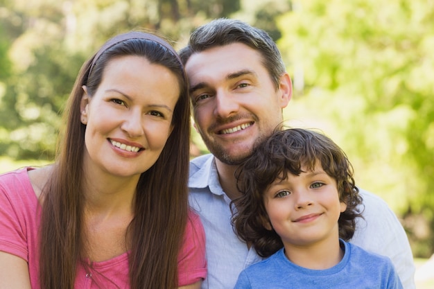 Close-up de um casal sorridente com filho no parque