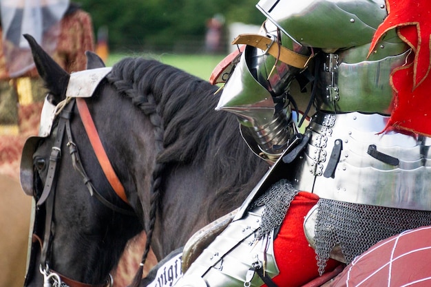 Close-up de um cavaleiro medieval vestindo armadura sentado a cavalo