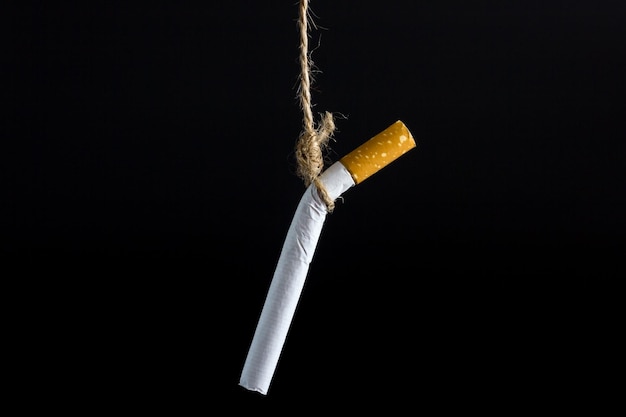 Close-up de um cigarro contra um fundo preto