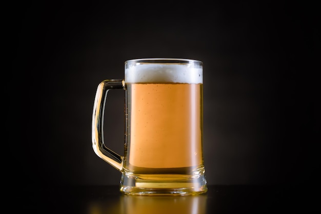 Close-up de um copo de cerveja contra um fundo preto