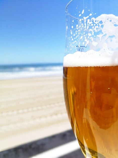 Foto close-up de um copo de cerveja na praia