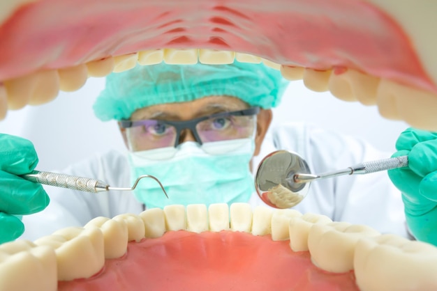 Close-up de um dentista masculino examinando o molde dental