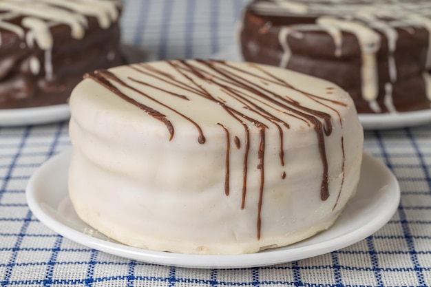 Foto close-up de um doce típico alfajor de chocolate branco na argentina em uma toalha de mesa quadriculada