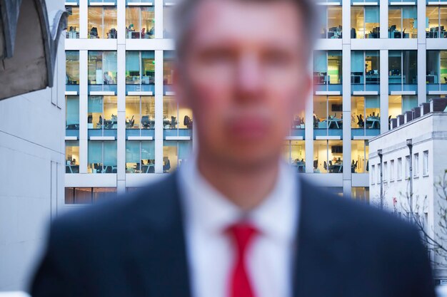 Foto close-up de um empresário contra um edifício de escritórios na cidade