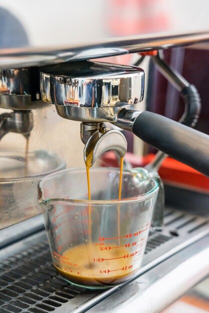 Close-up de um expresso a ser derramado da máquina de café.