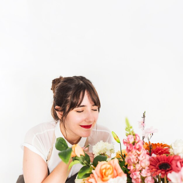 Close-up, de, um, femininas, florista, cheirando, flores, branco, fundo