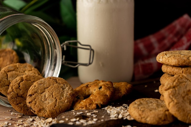 Close-up de um frasco de biscoito de uva de aveia caído e uma torre de biscoito ao lado.