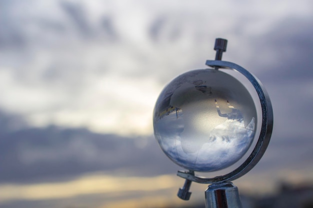 Foto close-up de um globo de vidro contra um céu nublado