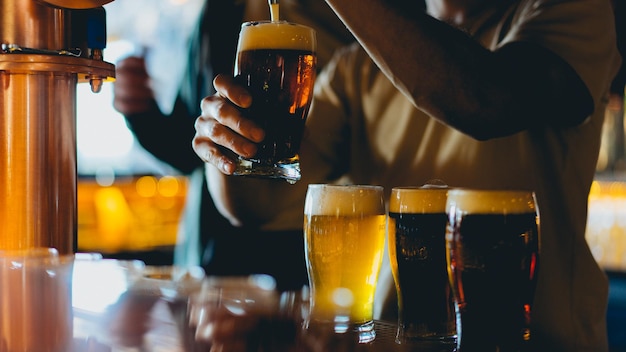 Close-up de um homem a verter cerveja num bar