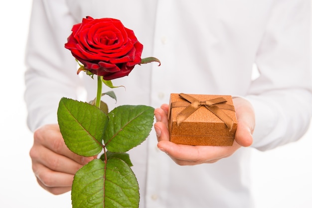 Foto close-up de um homem bonito com uma rosa vermelha e um presente