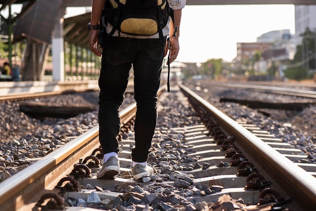 Close-up de um homem caminhando ao longo da ferrovia sem destino