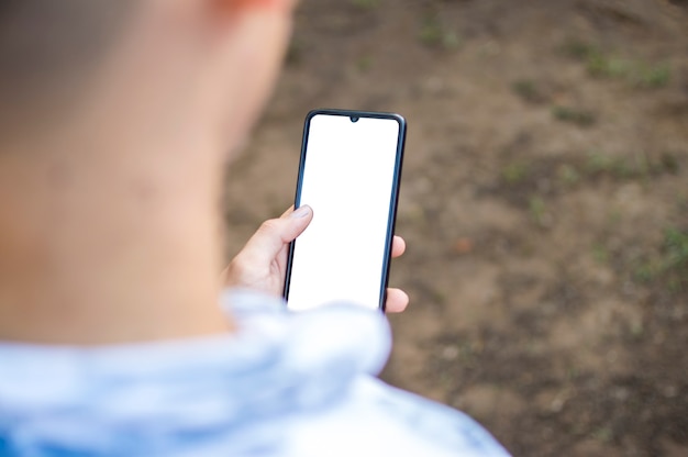 Close-up de um homem com o celular na mão, close-up, foto de uma pessoa verificando o celular, jovem com o celular na mão com espaço de cópia